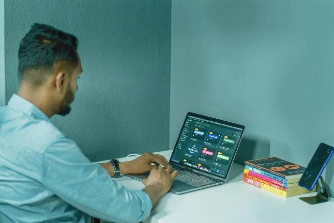 a man sitting at a desk using a laptop computer